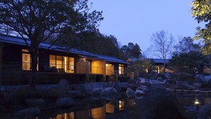 Un edificio tradicional japonés con ventanas amplias y un estanque de carpas.
