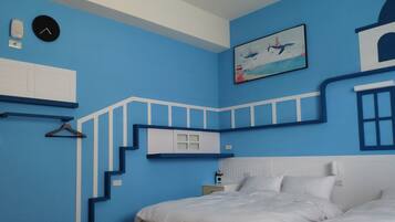 A bedroom with a blue wall, a bed, a nightstand, a clock, and a painting of a lighthouse.