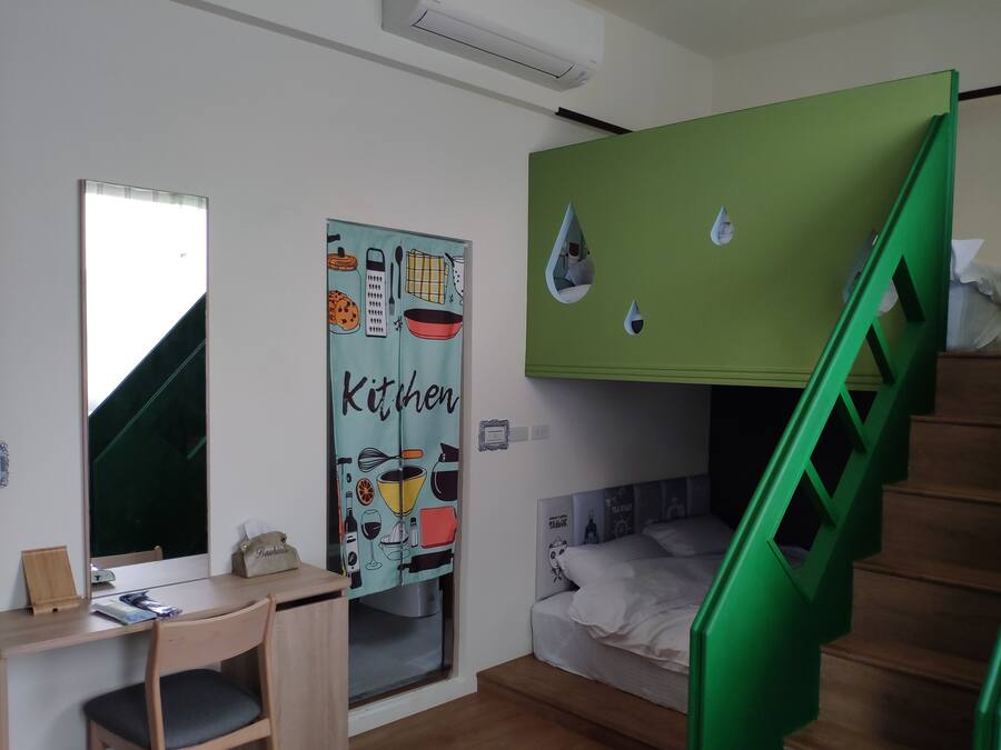 Un dormitorio con una cama litera, un escritorio y una silla.