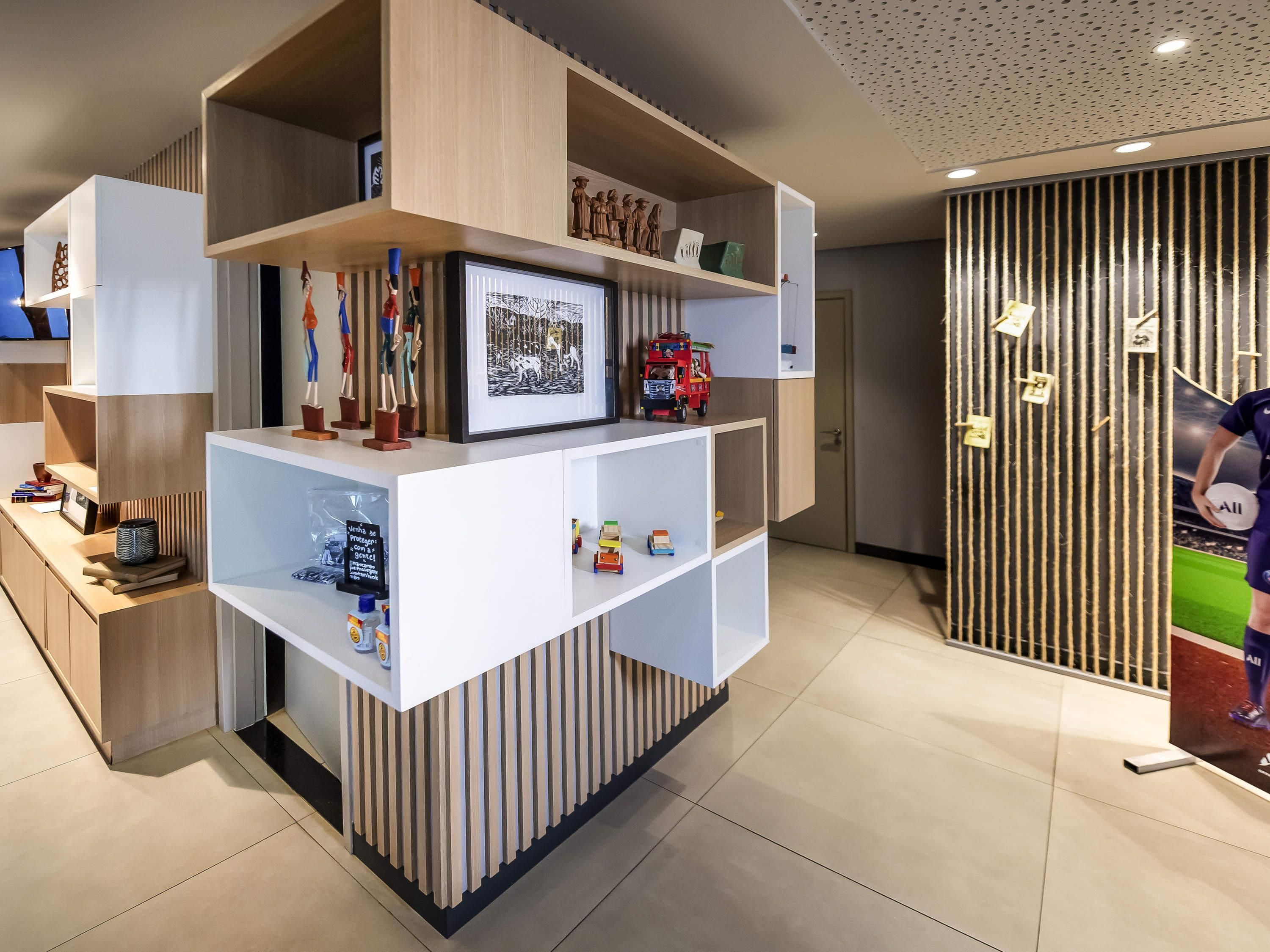A modern reception desk with a framed picture, a small TV, and various decorative items.