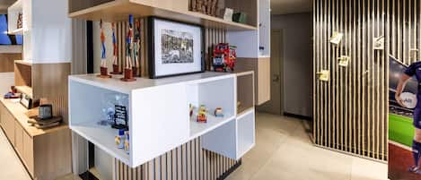 A modern reception desk with a framed picture, a small TV, and various decorative items.