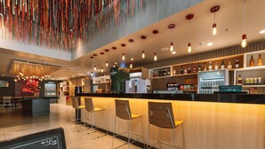 A bar area with a counter, stools, and a menu board. - Ibis Juazeiro do Norte (Juazeiro do Norte)