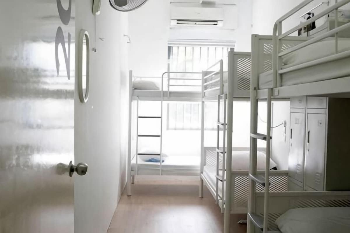 Una habitación con literas, una escalera, un armario y una puerta.