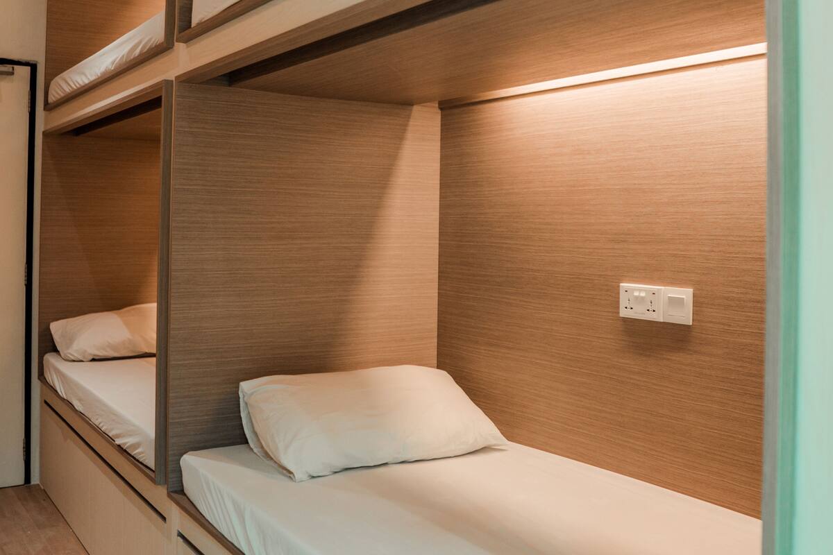 A bunk bed room with a wooden headboard and a single bed at the bottom.