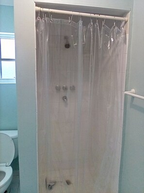 Bathtub, towels, soap, toilet paper