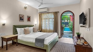 A hotel room with a bed, bedside table, TV, and a view of the outside. - La Vaiencia Beach Resort (Morjim)