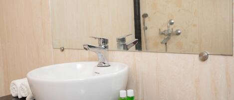 A bathroom with a white sink, a mirror, and a tray with two bottles of shampoo and a bar of soap.