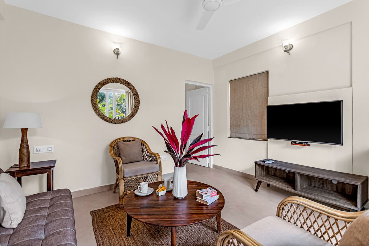 Una sala de estar con sofá, mesa de centro, televisor y chimenea.