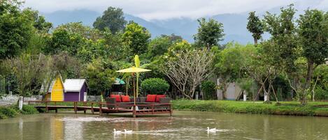 A floating structure with a yellow umbrella, a purple building, and a wooden deck.