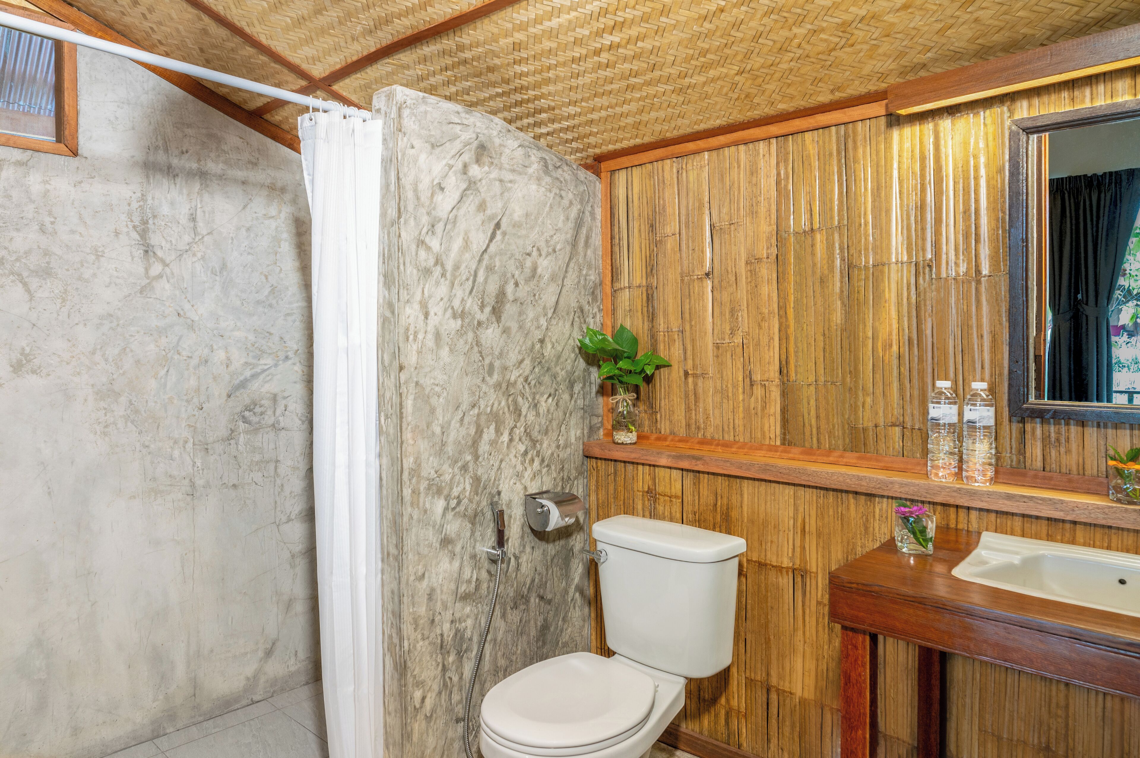 Ein Badezimmer mit Dusche, Toilette, Waschbecken und Spiegel.