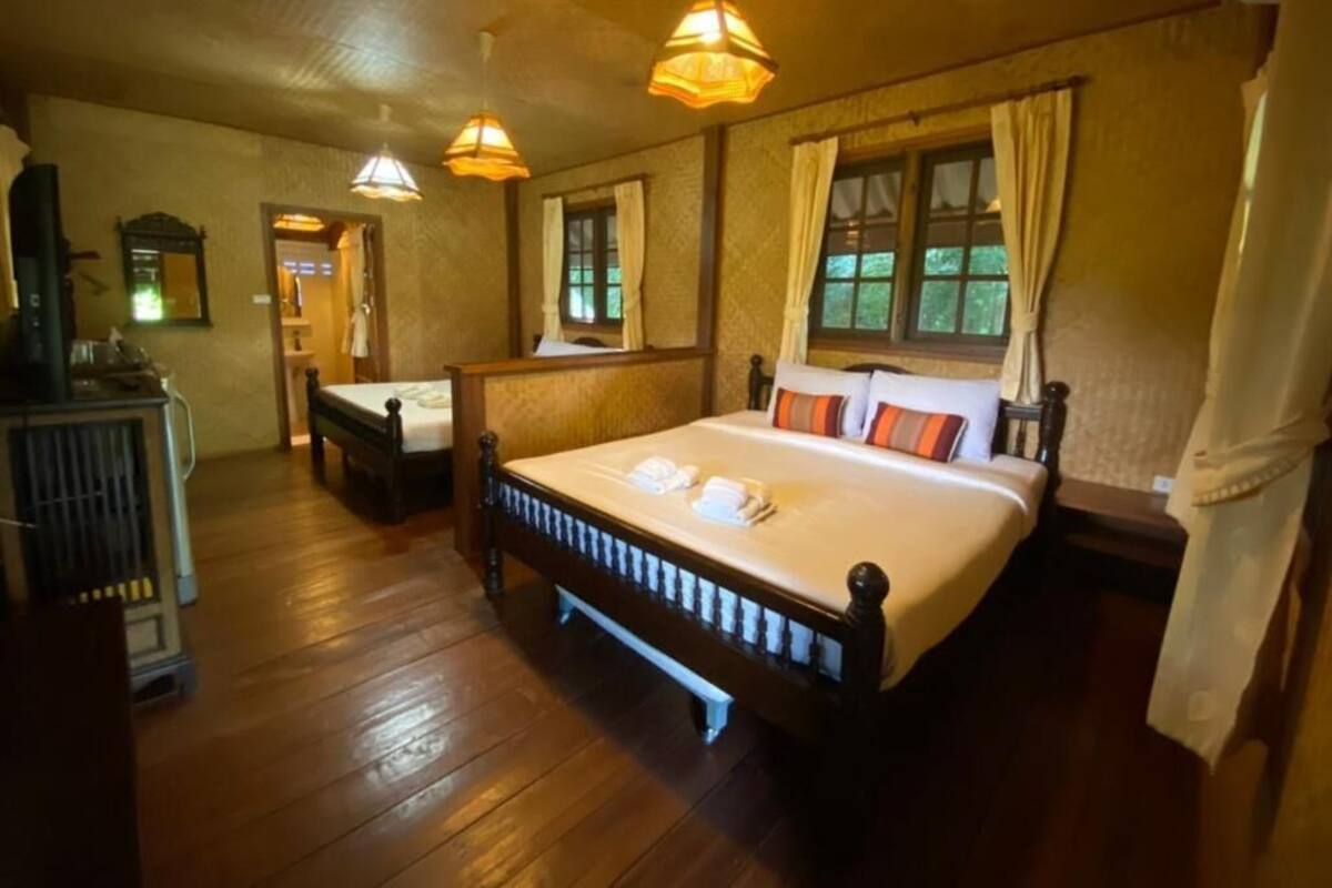 A traditional room with a large bed, two bedside tables, a mirror, and a radiator.