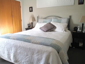 Restful retreat with a large bed, nightstand, and wardrobe.