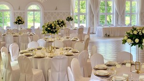 A banquet hall with round tables, white tablecloths, and floral centerpieces. - Nadodrzański Dwór (Nowa Sól)