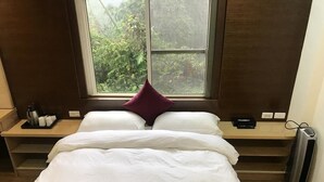 A neatly made bed with white and maroon bedding, a window with a view of greenery, a bedside table with a lamp, and a heater. - Zhu Yuan Homestay (Zhuqi)