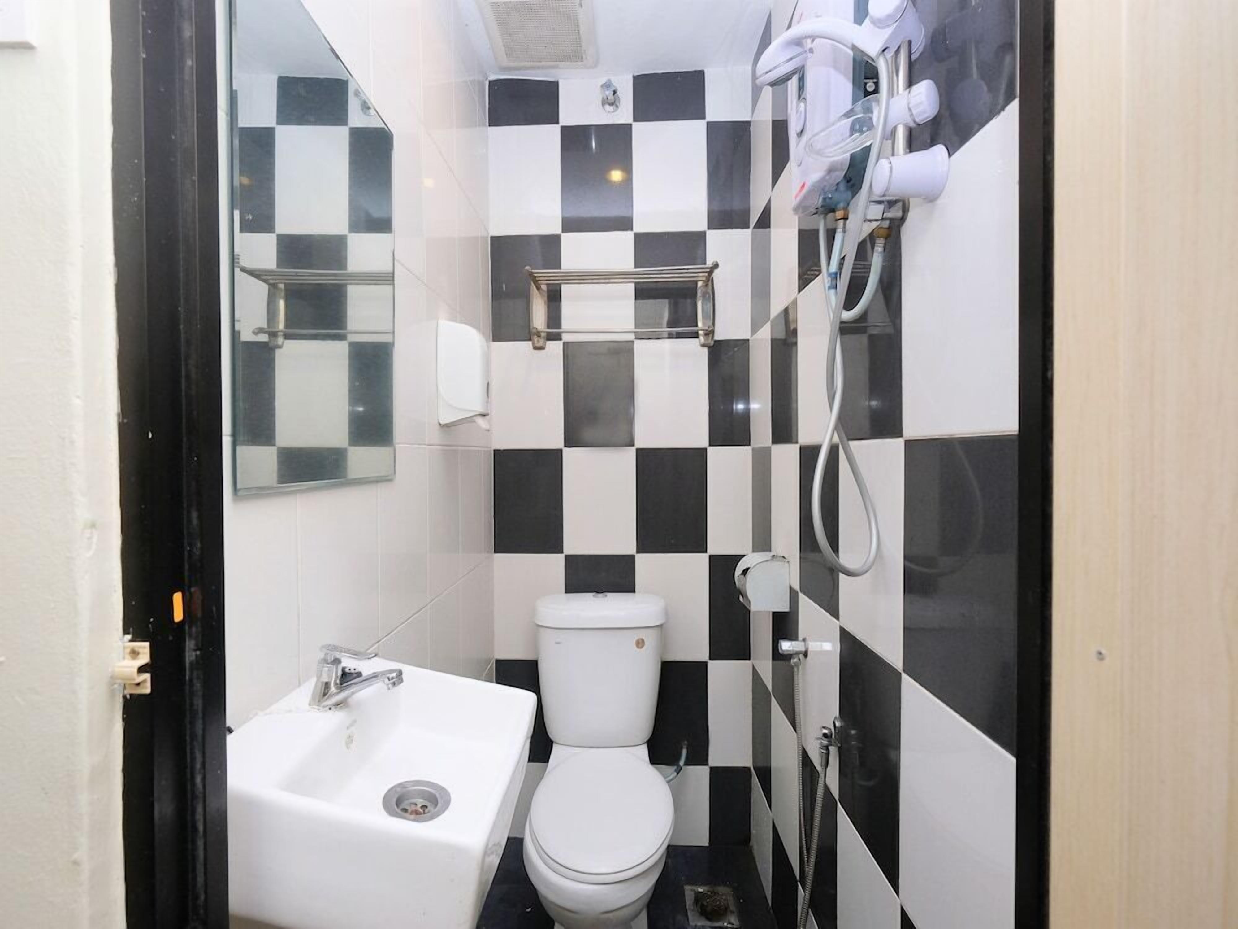 Une petite salle de bain avec un lavabo blanc, des toilettes et un espace douche.