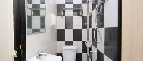 Une petite salle de bain avec un lavabo blanc, des toilettes et un espace douche.