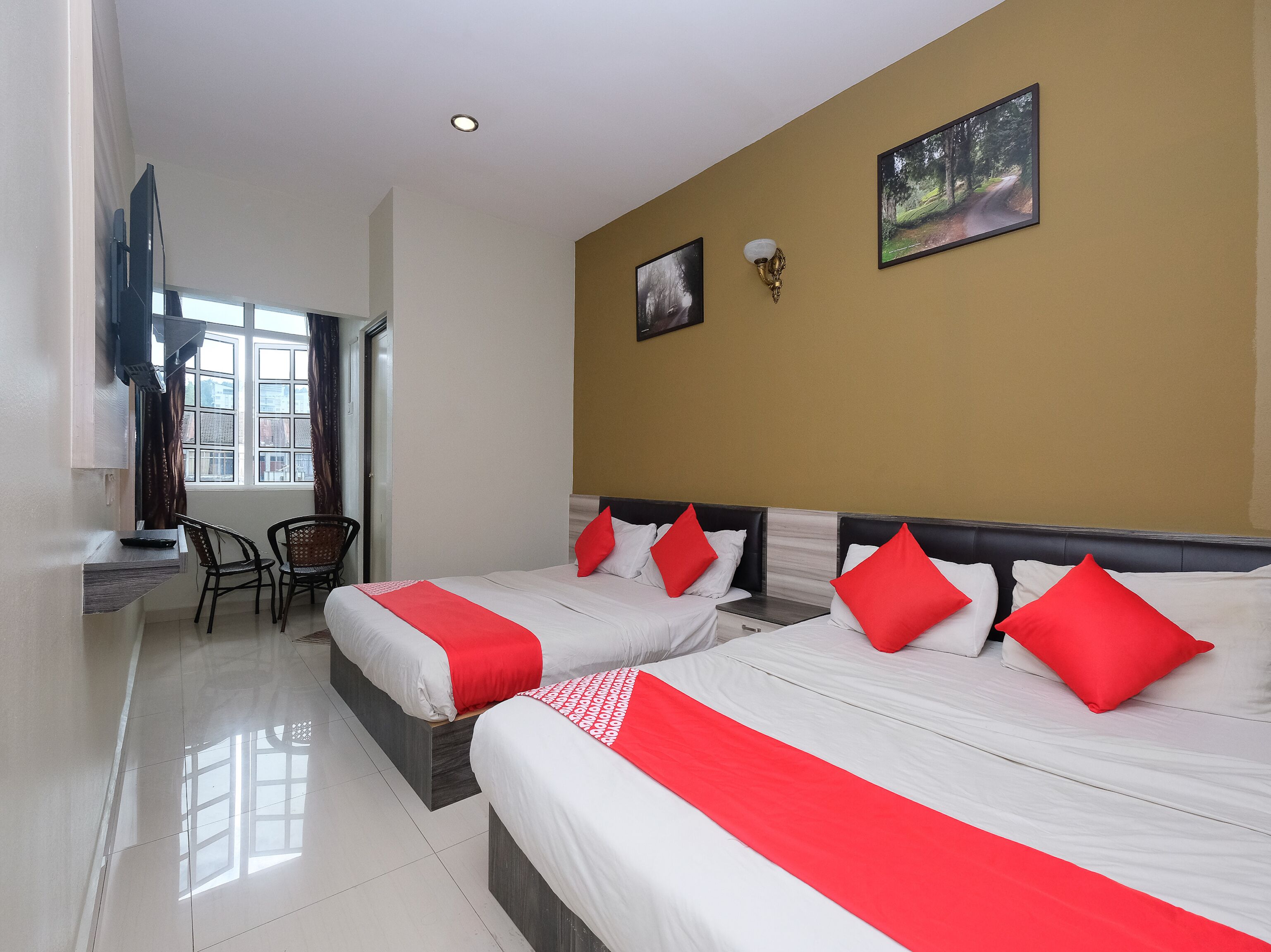 A hotel room with two beds, a desk, and a chair.
