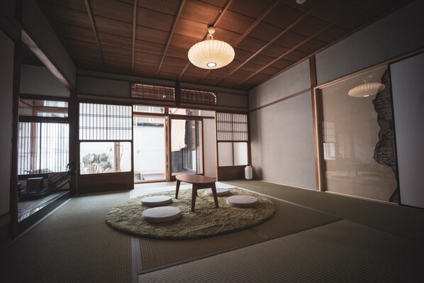 A traditional Japanese room with tatami flooring, a low wooden table, and shoji screens.