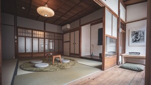 A traditional Japanese room with tatami flooring, a low wooden table, and sliding doors. - Modern Machiya MIBU (Kyoto)
