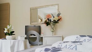 Una habitación de hotel con cama, televisión, escritorio y espejo.