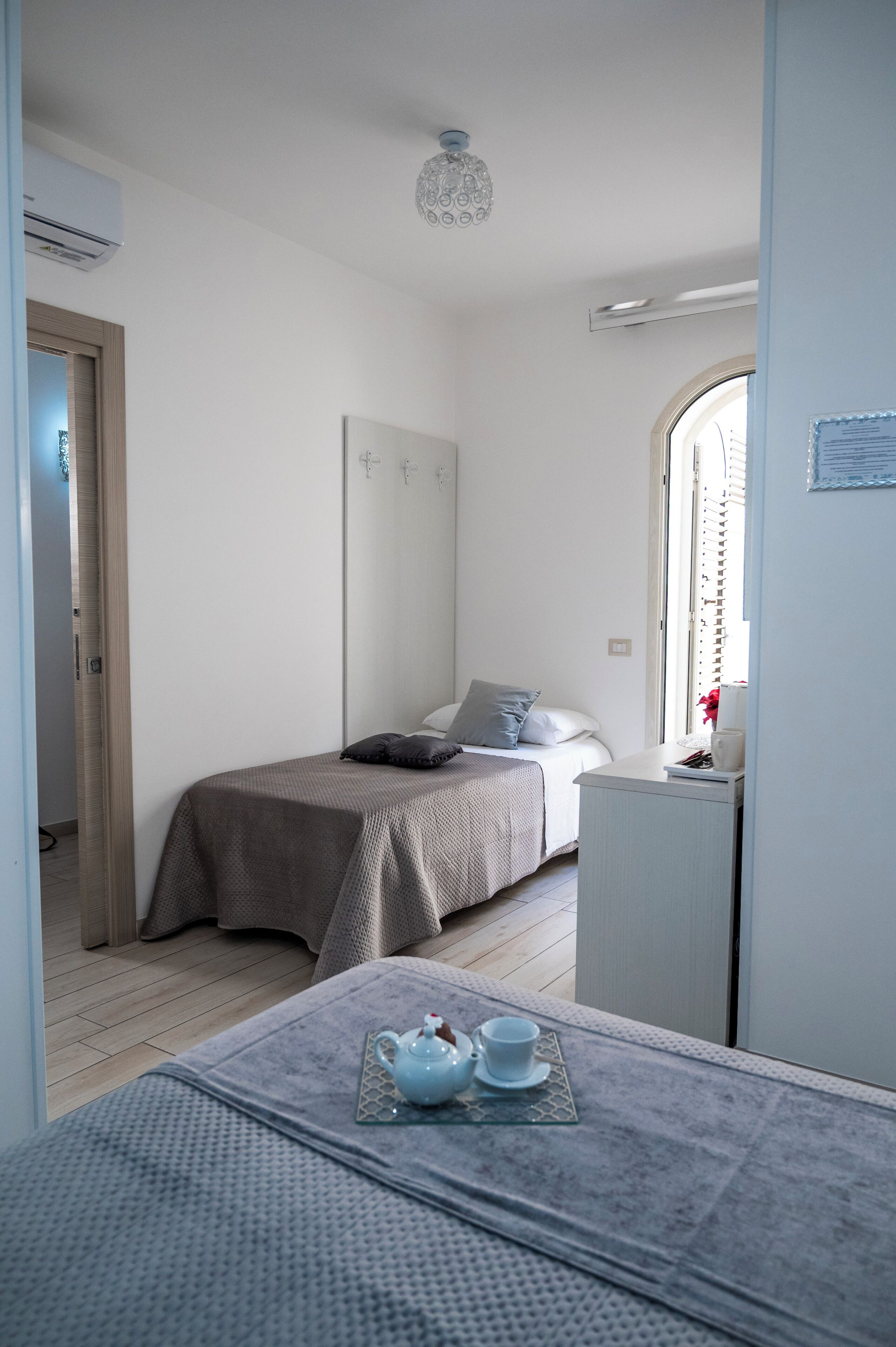 A bedroom with a bed, bedside table, and a small desk.