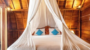 A bed with a canopy, wooden walls, and a heart-shaped headboard. - Sukawati Inn (Penida Island)