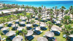 Playa privada, sillas reclinables de playa, sombrillas