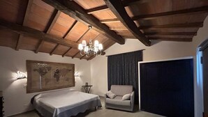 Une chambre à coucher avec un lit, une chaise, une carte accrochée au mur, un lustre et une grande fenêtre.