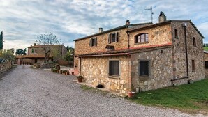 Une maison en pierre avec une allée en gravier et un petit jardin.