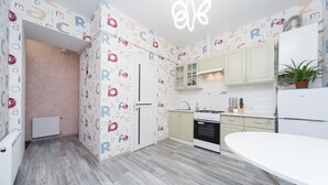 Una cocina moderna con armarios de color claro, una encimera blanca y un horno empotrado.