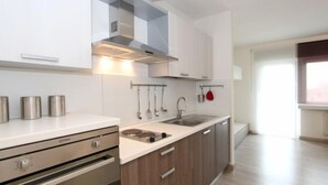 Eine moderne Küche mit Edelstahlgeräten, Holzschränken und einem eingebauten Backofen.