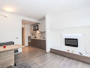 Een koelkast, een oven, kookgerei, borden en bestek