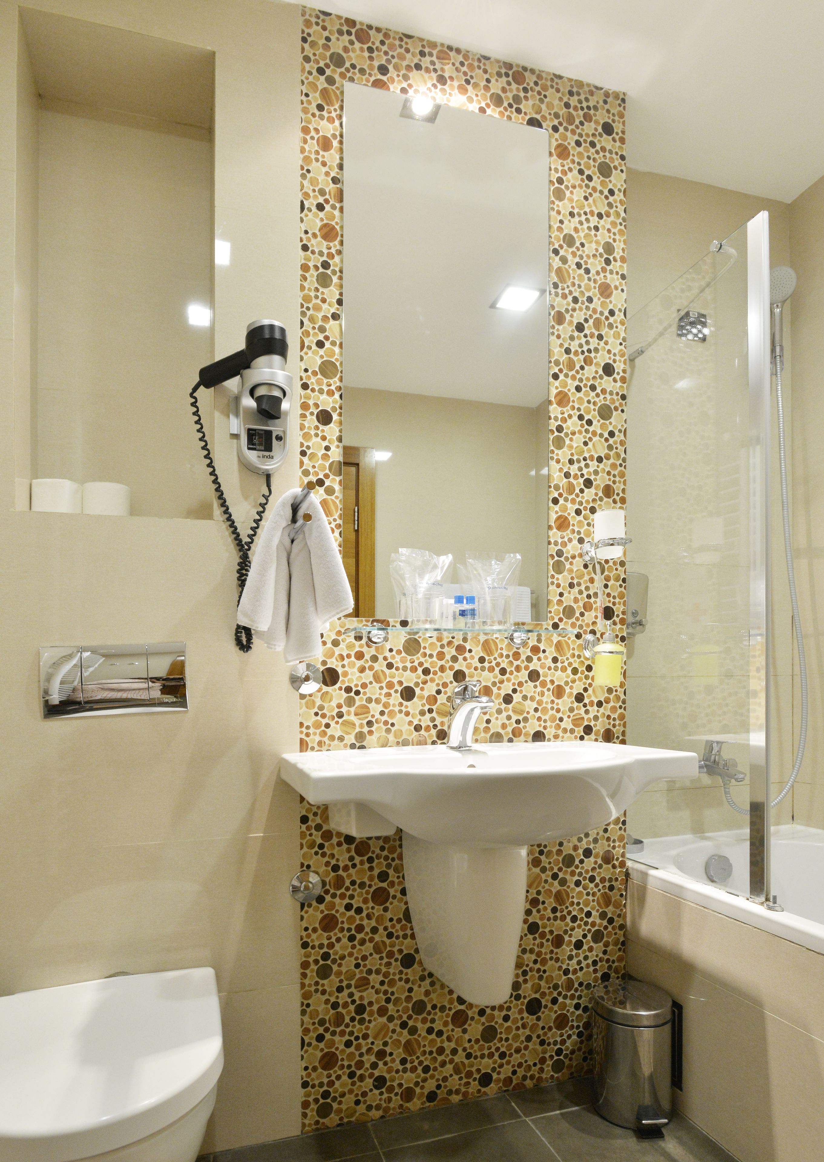 Ein Badezimmer mit Waschbecken, Spiegel, Toilette und Dusche.