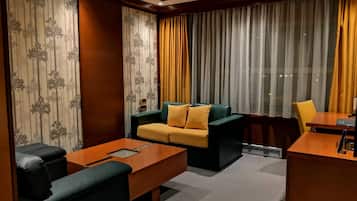 Junior Suite | Living area | 32-inch LCD TV with digital channels, TV, books