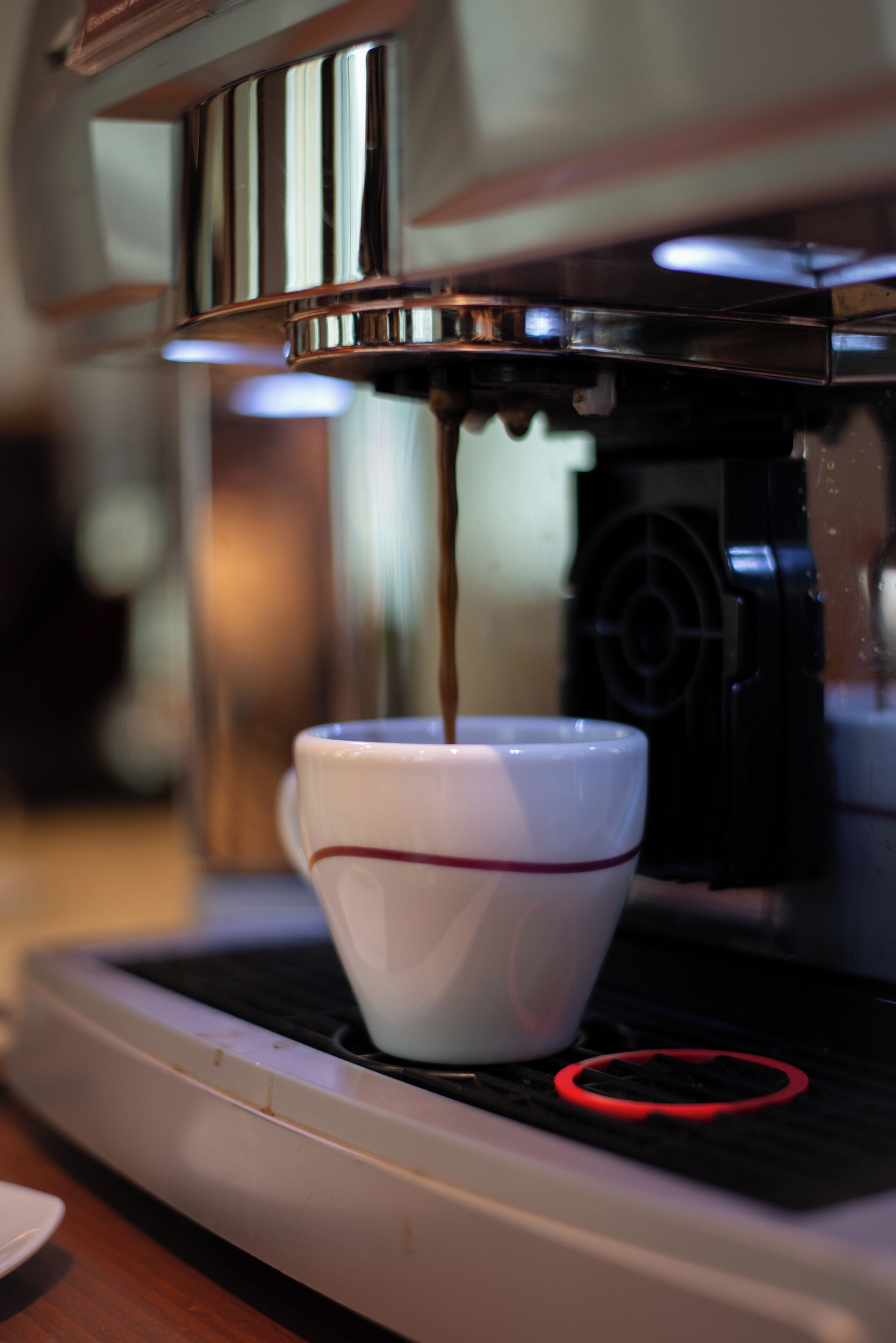 Una cafetera sirviendo café en una taza.