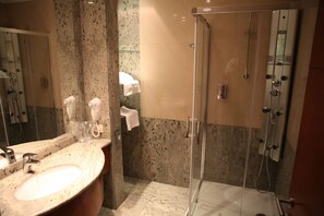 A bathroom with a sink, mirror, towel rack, and a glass-enclosed shower. - Garni Hotel Aleksandar (Novi Sad)