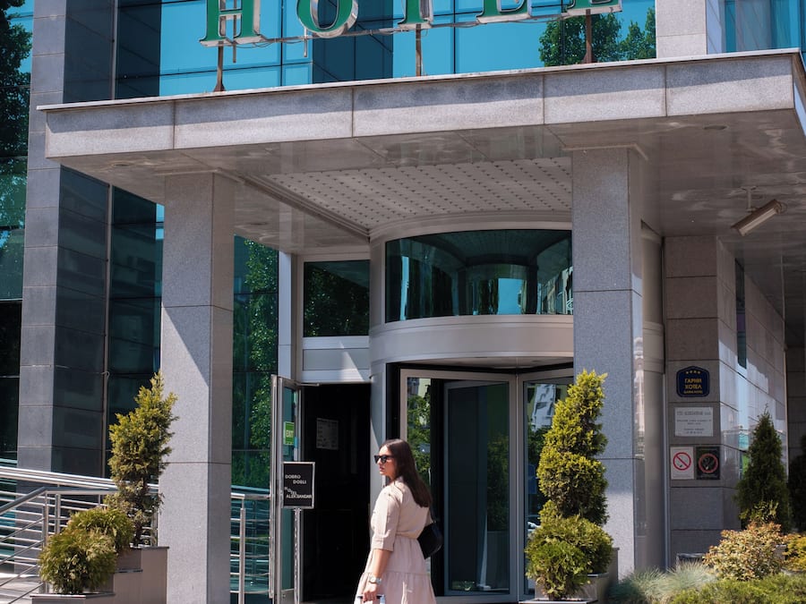 A modern hotel entrance with a clear sign reading 'HOTEL' above the doors.