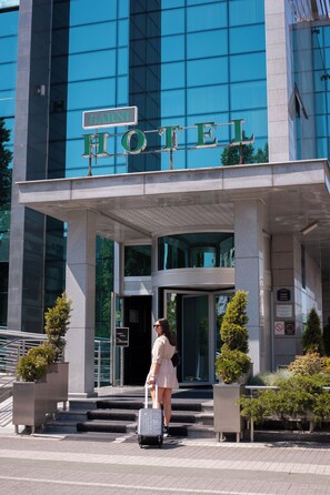 A modern hotel entrance with a clear sign reading 'HOTEL' above the doors. - Garni Hotel Aleksandar (Novi Sad)