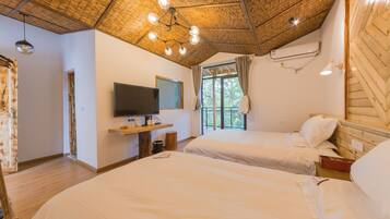 A room with two beds, a TV, and a wooden ceiling.