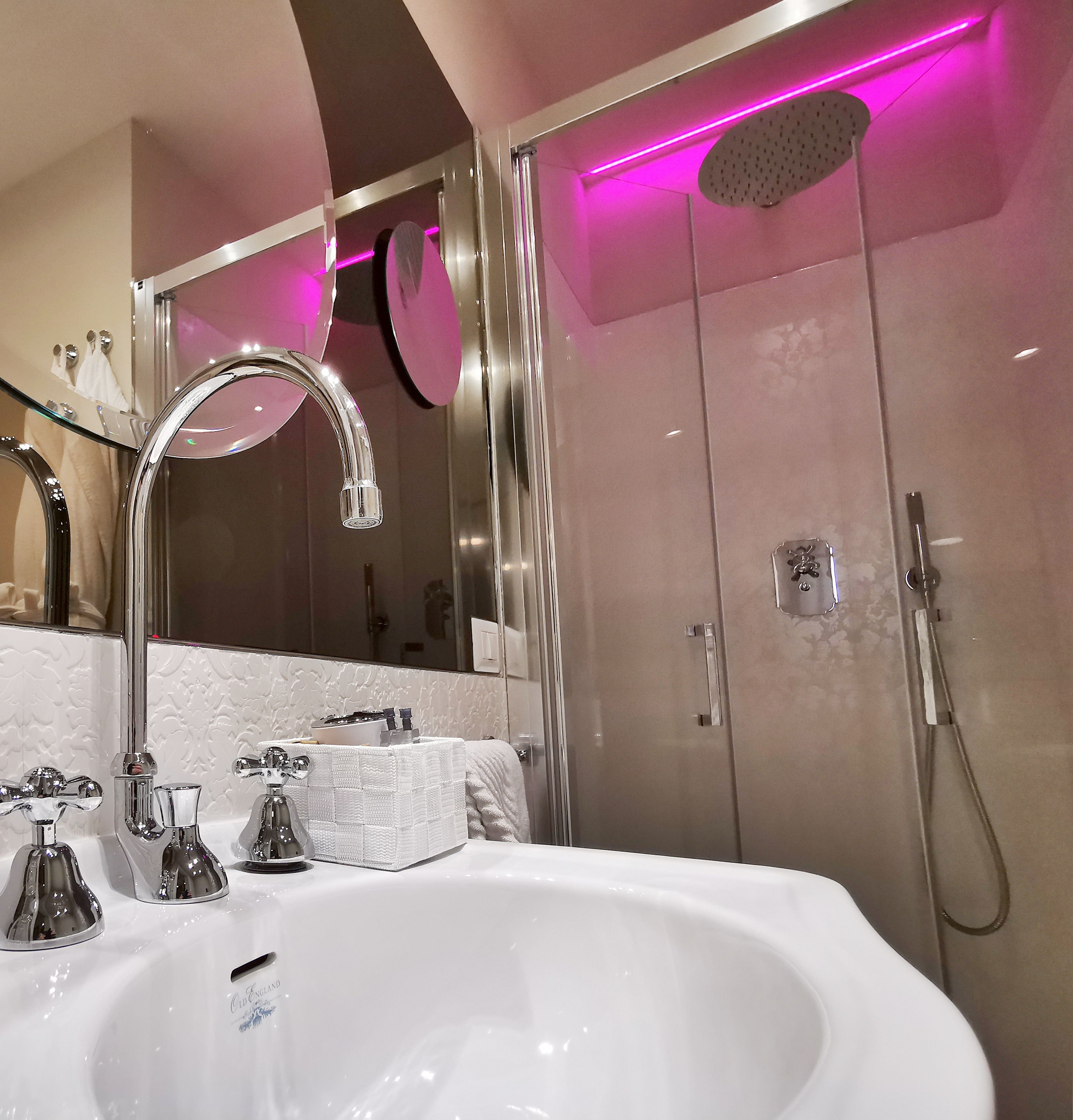 Un baño moderno con un lavamanos grande, un espejo y una zona de ducha.