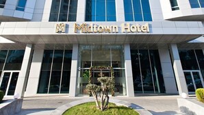 Un moderno edificio de hotel con un llamativo letrero que dice 'Midtown Hotel'.
