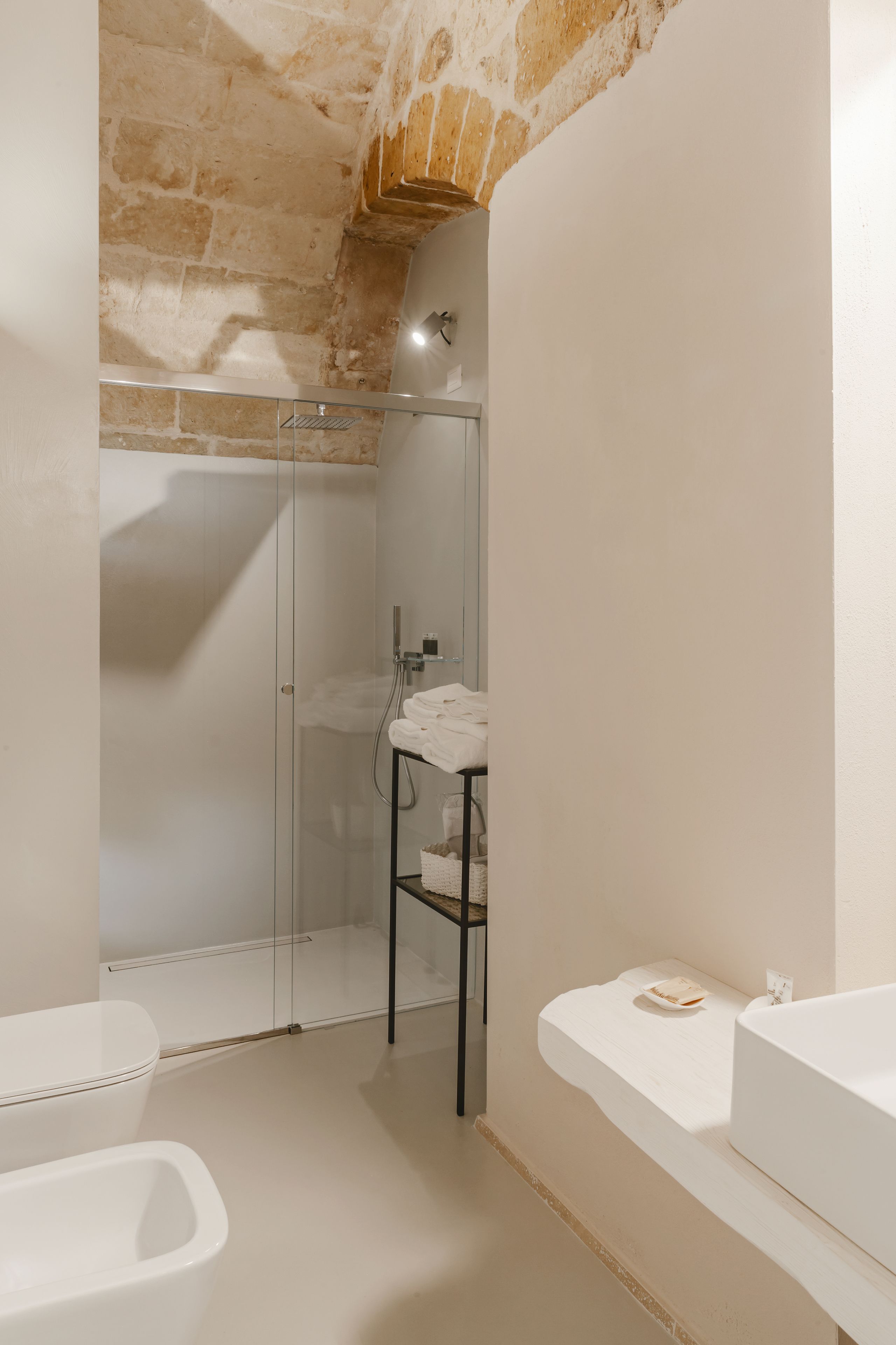 Une salle de bain moderne avec une douche à parois de verre, un lavabo blanc et une baignoire.