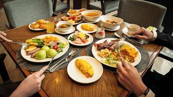 Una mesa de comedor con diversos platos, utensilios y sillas.