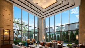 Un espace intérieur vaste et lumineux, doté de grandes fenêtres, de sièges confortables et d’un lustre moderne.