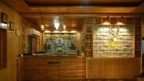 Un área de recepción con un mostrador de madera, un reloj y un cartel que dice "Hotel Royal Palace".