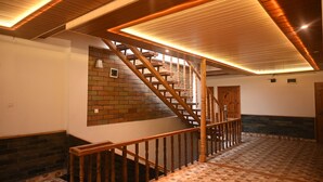 Una escalera de madera con un detalle de pared de ladrillo, suelo estampado e iluminación empotrada.