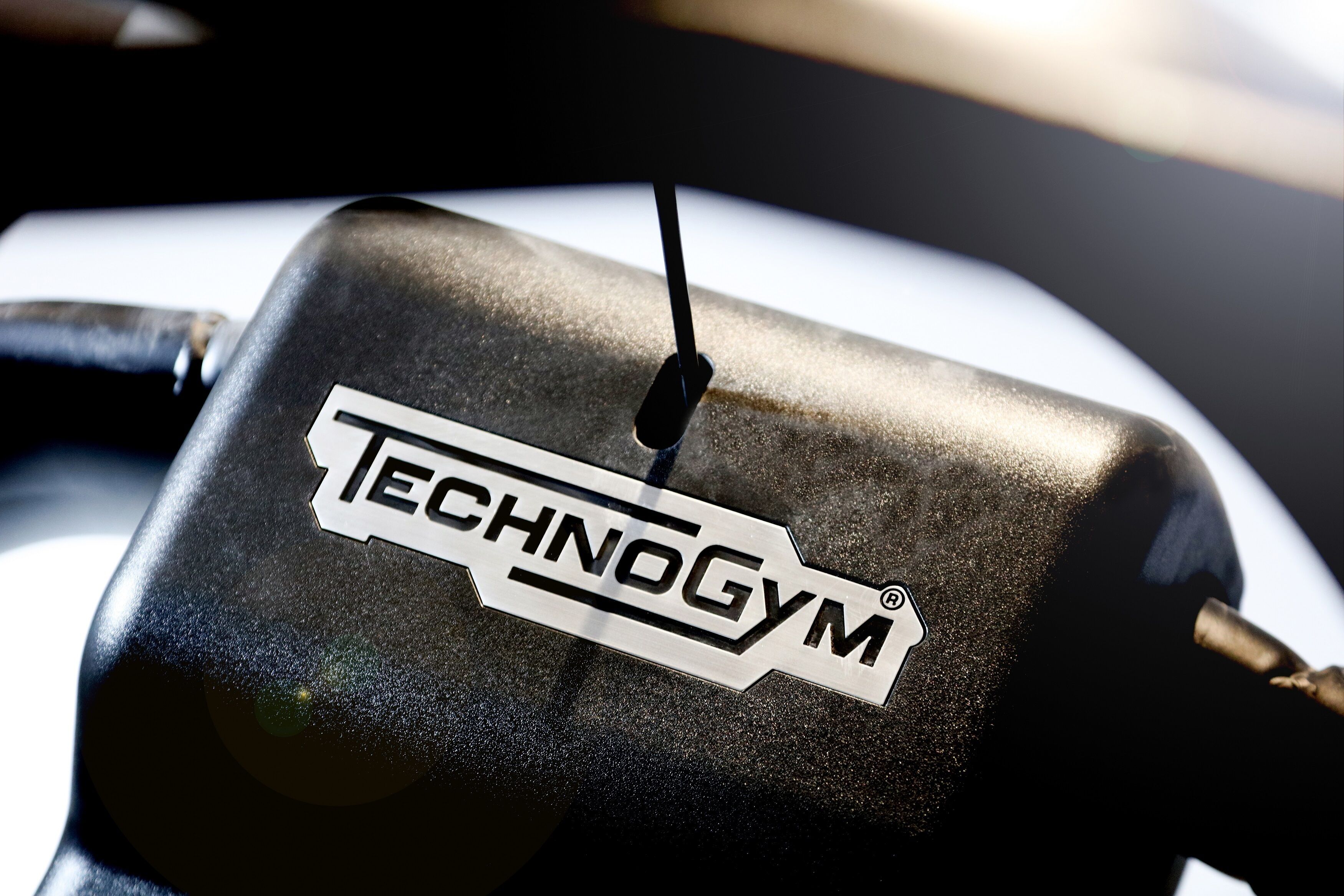Een close-up van een zwart object met een wit label waarop 'TECHNOGYM' staat.