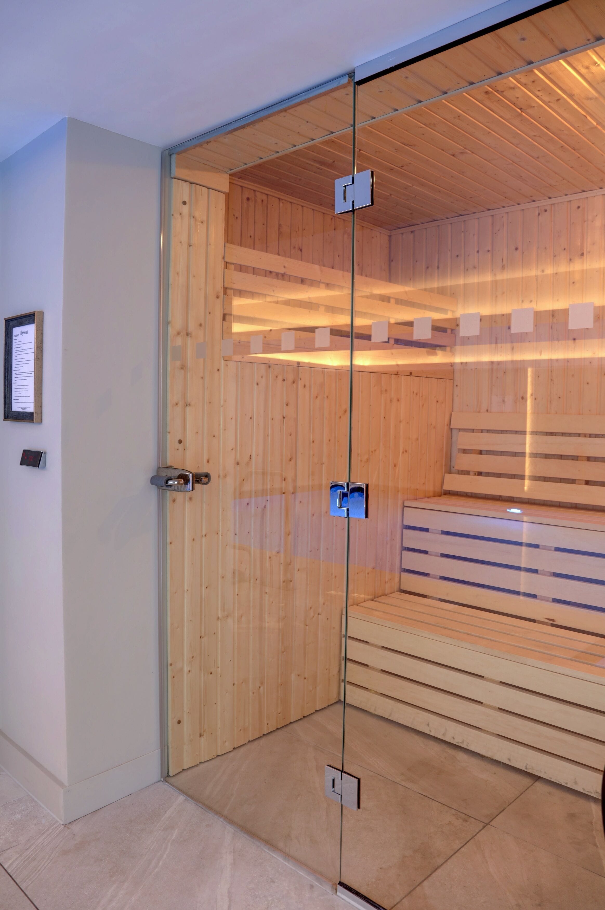 A modern room with a glass partition, wooden paneling, and built-in benches.