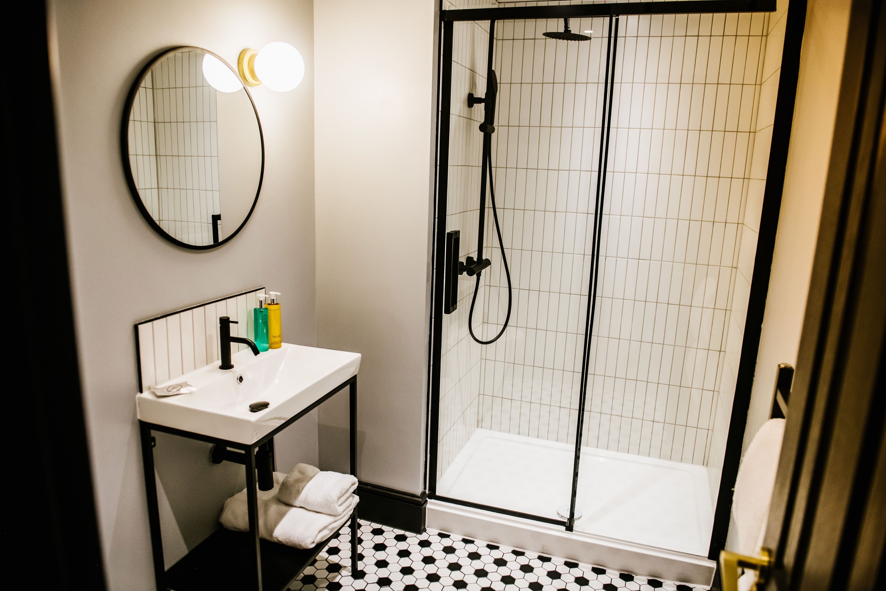 A bathroom with a white sink, a mirror, and a glass-enclosed shower.