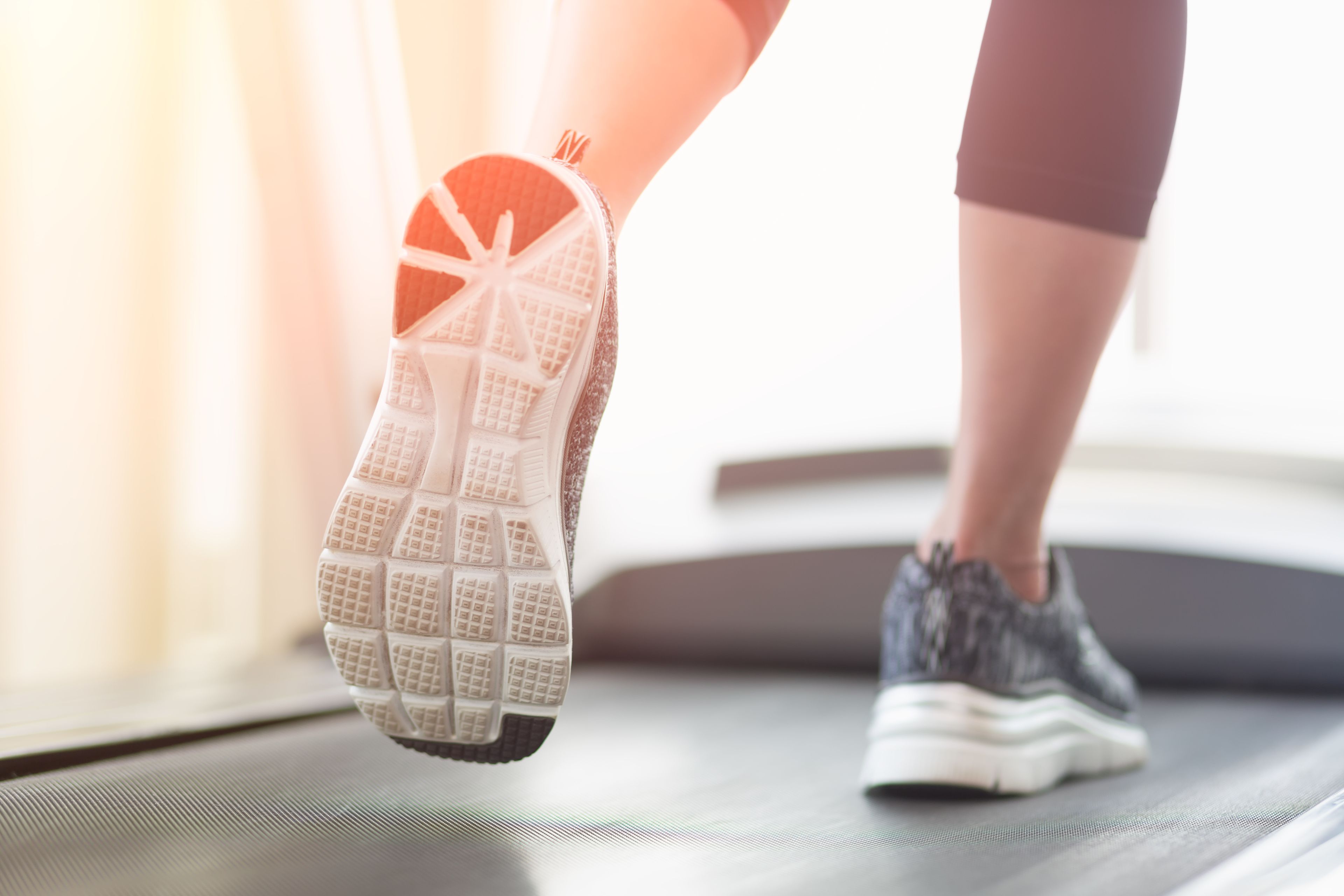 A close-up of a person's foot wearing a running shoe on a treadmill.